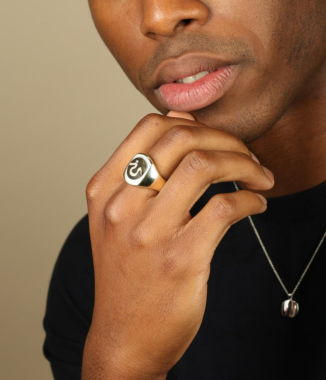 picture of a man wearing the London Oak ring in solid white gold and also wearing a silver signet necklace